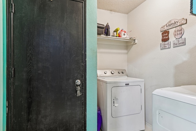 laundry room with washer and dryer and a textured ceiling