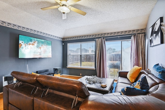 home theater room featuring a textured ceiling, hardwood / wood-style flooring, and ceiling fan