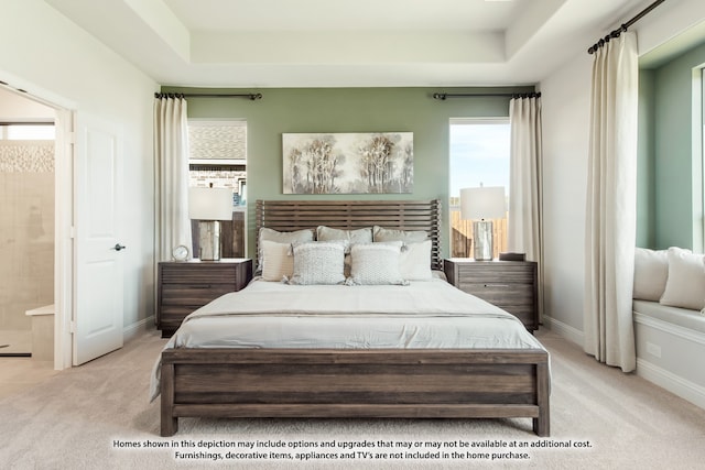 carpeted bedroom featuring connected bathroom and a raised ceiling