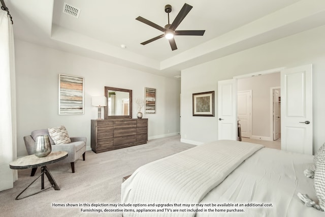 carpeted bedroom with a tray ceiling and ceiling fan