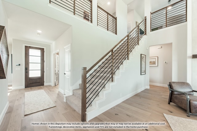 foyer featuring light hardwood / wood-style flooring and a towering ceiling