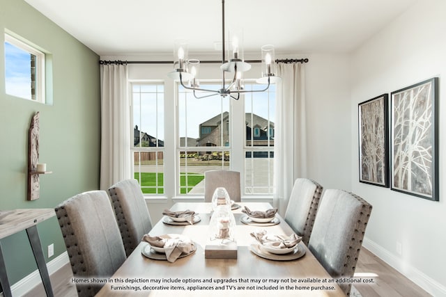 dining space featuring an inviting chandelier, light wood-type flooring, and a healthy amount of sunlight