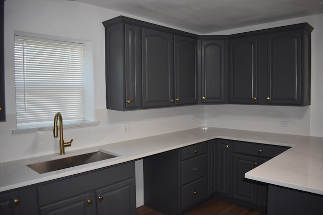 kitchen featuring sink, light stone countertops, and dark hardwood / wood-style floors