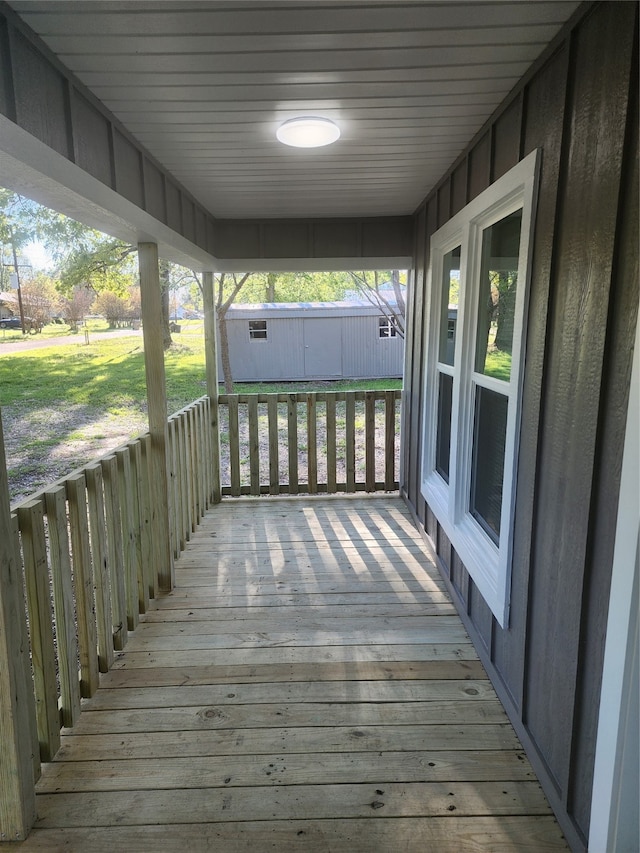 deck featuring a storage shed and a lawn