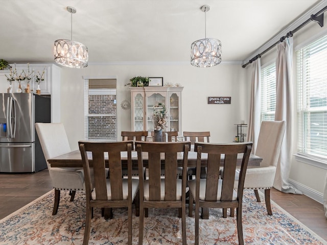 dining area featuring ornamental molding, dark hardwood / wood-style floors, and a chandelier