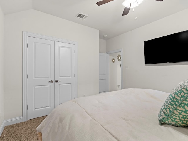 carpeted bedroom featuring ceiling fan, lofted ceiling, and a closet