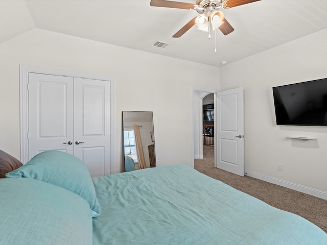 carpeted bedroom featuring vaulted ceiling, ceiling fan, and a closet