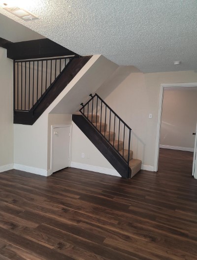 stairs featuring hardwood / wood-style floors and a textured ceiling