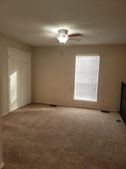 spare room with carpet, a textured ceiling, and ceiling fan