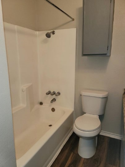 bathroom featuring toilet, hardwood / wood-style flooring, and shower / bath combination