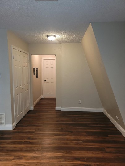 interior space with dark wood-type flooring and a textured ceiling