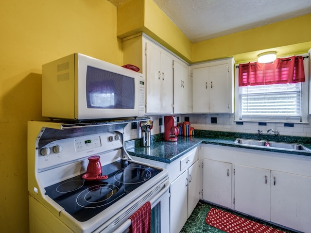 kitchen featuring white cabinetry, tasteful backsplash, sink, and white appliances