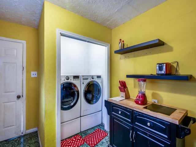 washroom featuring washing machine and dryer and a textured ceiling