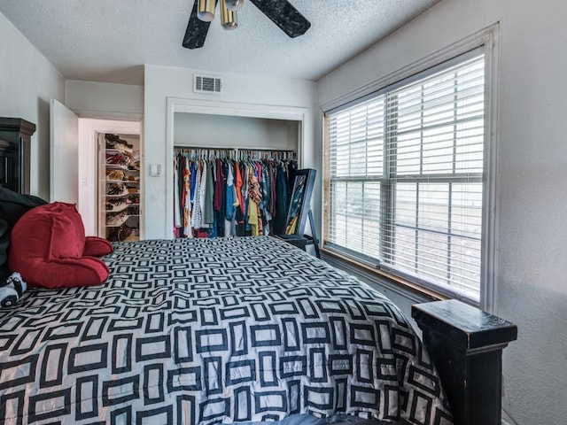 bedroom featuring a closet, ceiling fan, and a textured ceiling