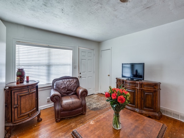 interior space with a textured ceiling and hardwood / wood-style flooring