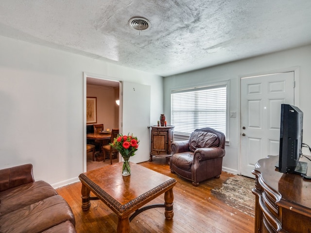 living room with a textured ceiling and hardwood / wood-style floors