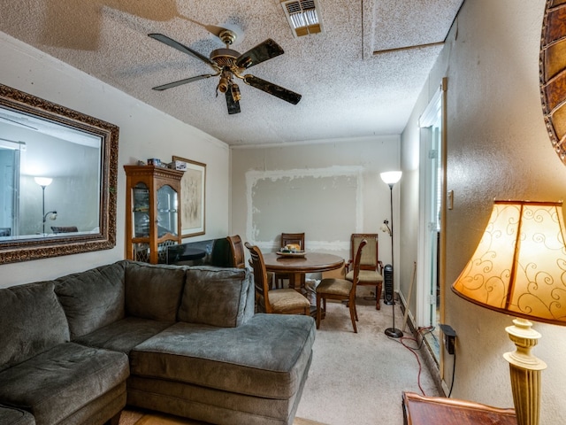 carpeted living room featuring ceiling fan and a textured ceiling