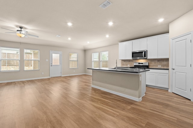 kitchen with sink, light hardwood / wood-style flooring, stainless steel appliances, and white cabinets