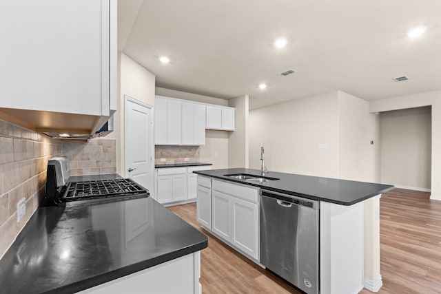 kitchen featuring white cabinets, a center island with sink, backsplash, sink, and stainless steel appliances