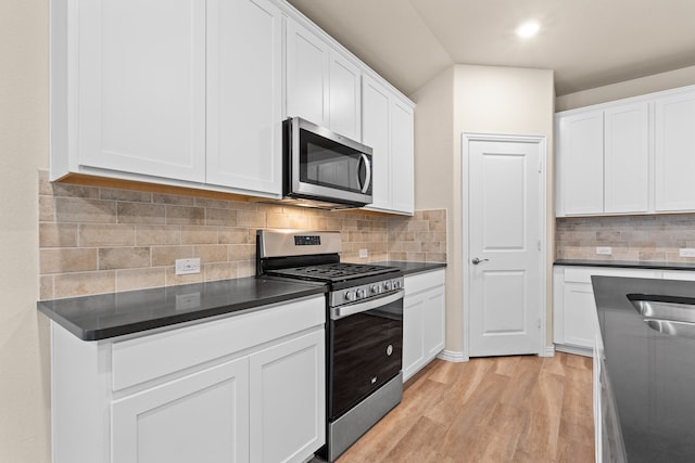 kitchen with stainless steel appliances, decorative backsplash, light hardwood / wood-style flooring, and white cabinets