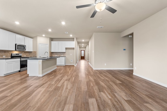 kitchen with white cabinetry, stainless steel appliances, and light wood-type flooring