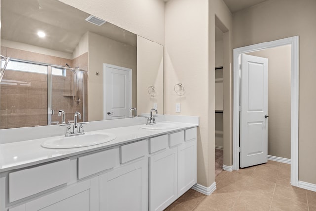 bathroom featuring vanity, a shower with shower door, and tile patterned flooring