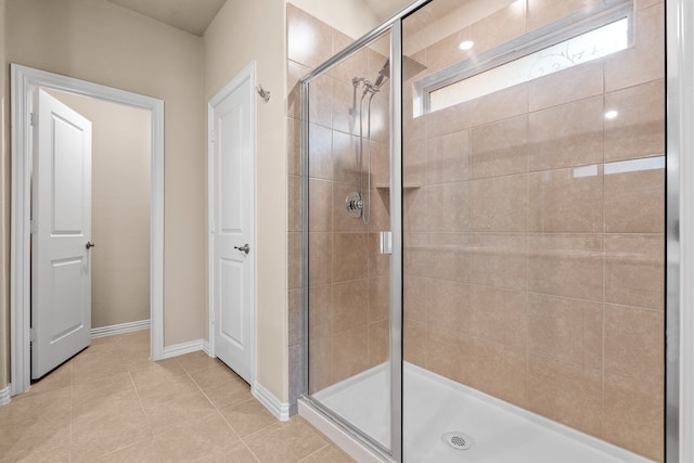 bathroom with a shower with door and tile patterned floors