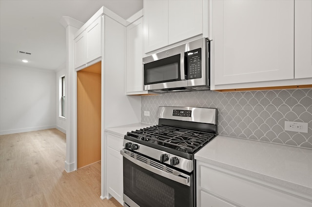 kitchen featuring white cabinetry, light hardwood / wood-style floors, tasteful backsplash, and appliances with stainless steel finishes