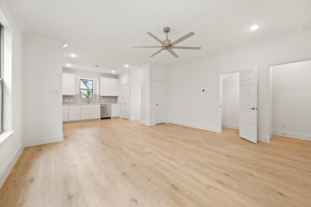 unfurnished living room featuring ornamental molding, sink, light hardwood / wood-style flooring, and ceiling fan