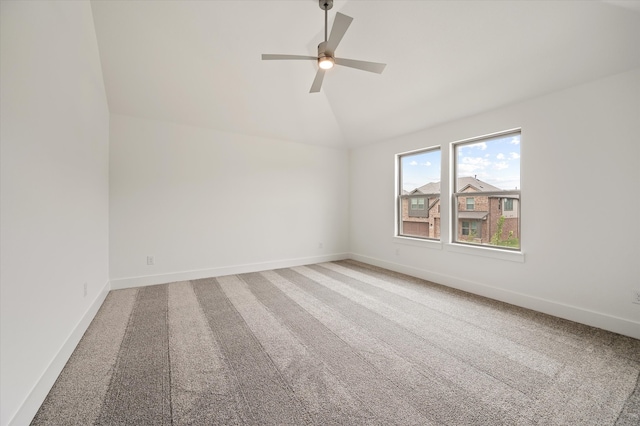 carpeted spare room with vaulted ceiling and ceiling fan