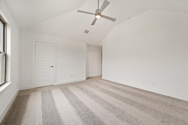 carpeted empty room featuring ceiling fan and vaulted ceiling