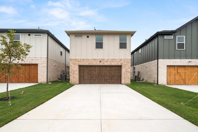 view of front of house featuring central air condition unit, a front yard, and a garage