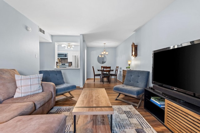 living room featuring an inviting chandelier and hardwood / wood-style floors