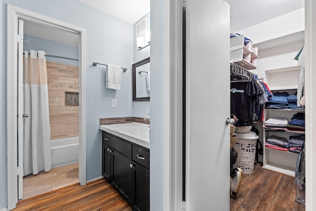 bathroom featuring vanity, hardwood / wood-style floors, and shower / bathtub combination with curtain