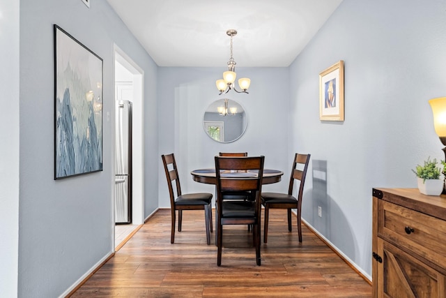 dining room with an inviting chandelier and dark wood-type flooring