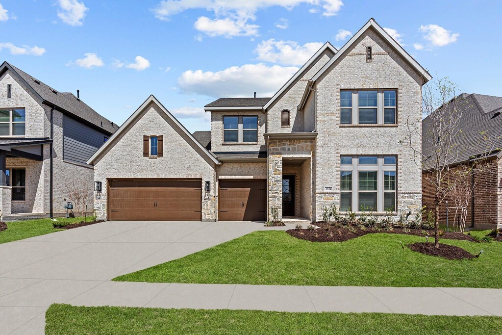 view of front of property featuring a front yard and a garage