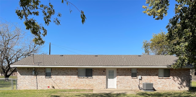 back of property featuring central AC and a yard