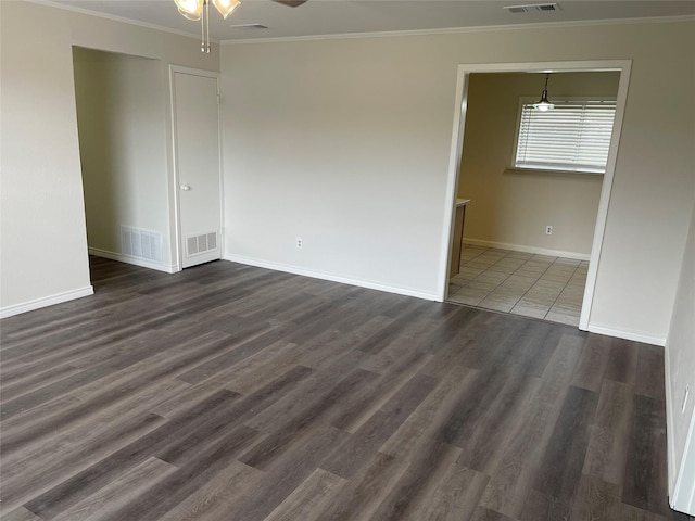 spare room with dark wood-type flooring, ceiling fan, and crown molding