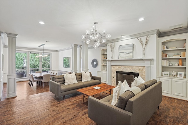 living room with a fireplace, dark wood-type flooring, crown molding, a chandelier, and built in shelves