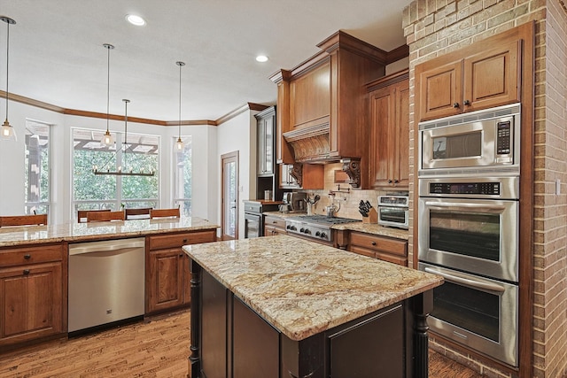 kitchen with hardwood / wood-style flooring, hanging light fixtures, stainless steel appliances, crown molding, and a center island