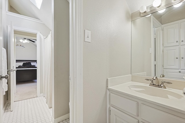 bathroom with vanity, ceiling fan, tile patterned floors, and lofted ceiling