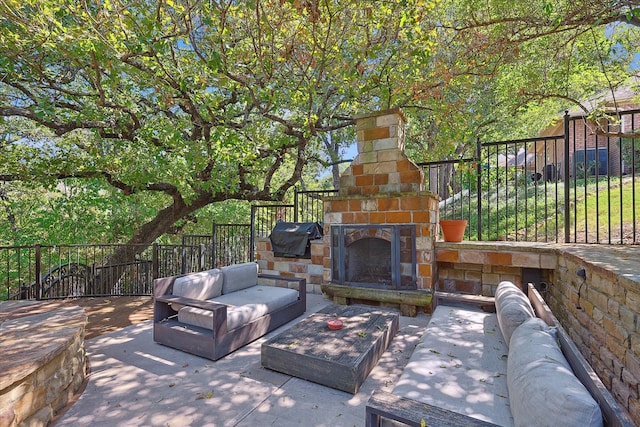 view of patio with area for grilling and an outdoor stone fireplace