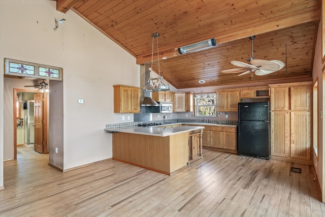 kitchen with black refrigerator, pendant lighting, kitchen peninsula, and ceiling fan