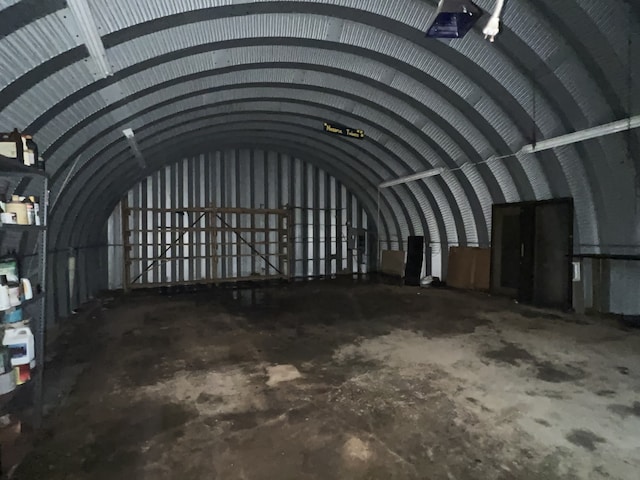 miscellaneous room with lofted ceiling and concrete floors