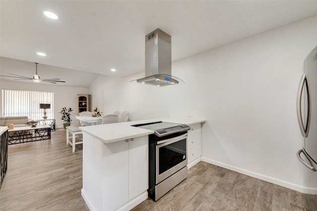 kitchen featuring light hardwood / wood-style floors, kitchen peninsula, island exhaust hood, and stainless steel appliances