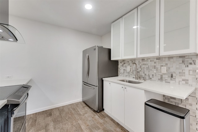 kitchen featuring white cabinetry, stainless steel appliances, sink, and light wood-type flooring