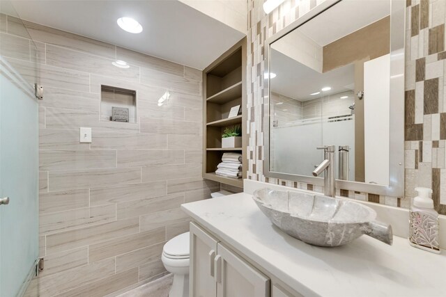 11306 Park Central Pl Unit D, Dallas, TX 75230 - full bathroom featuring tile walls, vanity, toilet, and a stall shower