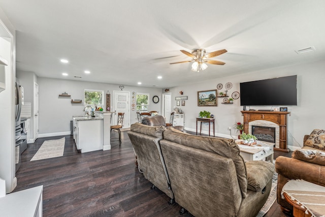 living room featuring ceiling fan and dark hardwood / wood-style flooring