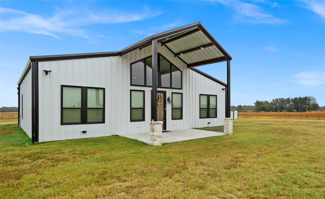 rear view of property featuring a yard and a patio area