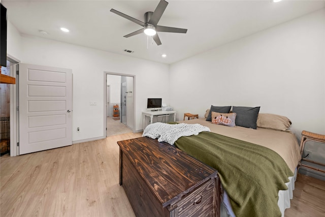 bedroom with connected bathroom, light wood-type flooring, and ceiling fan